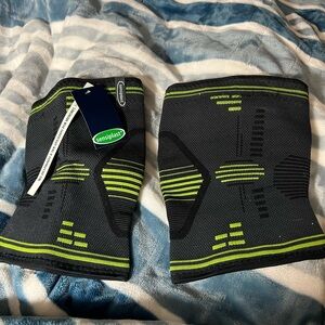 Two Black and Green Knee Support Compression Sleeves